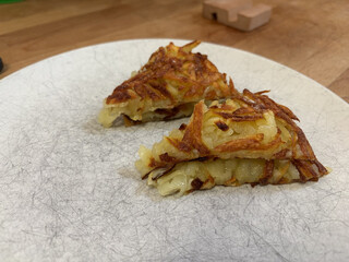 fertiger rösti aufgeschnitten auf einem weissen teller.