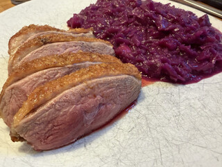 entenbrust in scheiben geschnitten mit TK-rotkohl auf einem weissen teller