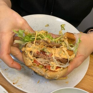 foto eines selbstgebauten big macs mit beyond meat patties, salat, zwiebeln, tomaten und selbstgemachter big mac sauce