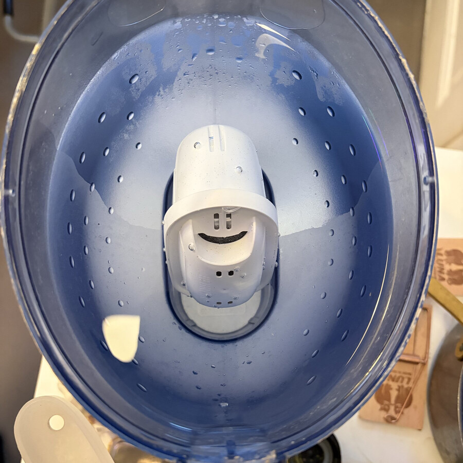 foto eines brita-filters im frischen wasser. die öffnungen des filters sehen aus wie ein lächelnder smiley