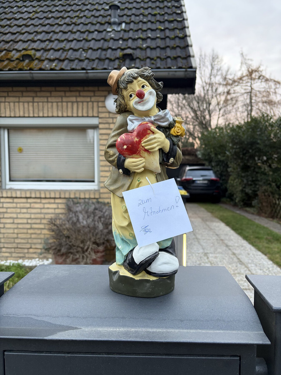 foto einer clown-figur die einen zettel trägt: „zum mitnehmen“