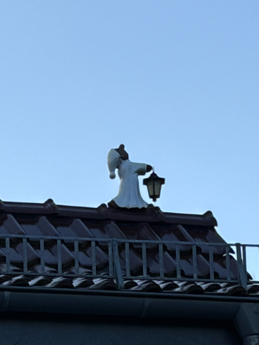 foto eines dachfirst mit einer kleinen keramik-figur eines schlafwandlers