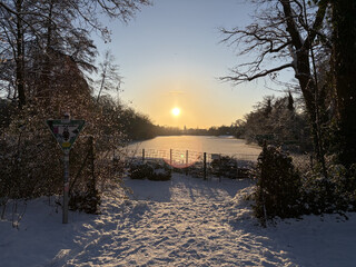 bild vom winterlichen, gefrorenem pl&ouml;tzensee, &uuml;ber dem see h&auml;ngt die morgensonne