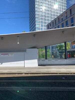 bild der architektonisch ambitionierten strassenbahnhaltestelle hauptbahnhof mit einem improvisierten, weiss gestrichenen holzverschlag