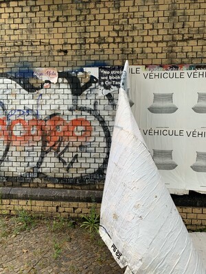 ein foto von einem abblätternden werbe-pappmaschee streifen, der offenabr nicht hielt weil die plakate auf graffitti geklebt waren.