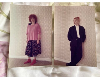 foto von zwei fotos, eins zeigt meiner mutter, eins zeigt mich an eine altmodisch zapezierte wand gelehnt. ich trage sowas wie einen anzug und ein weisses hemd, meine mutter einen rock und geschichtete pullover. meine haare sind bunt.