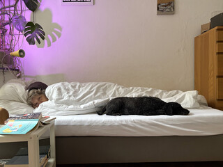 die beifahrerinliegt mit einem anorak im bett, frida liegt ausgestreckt danaben.