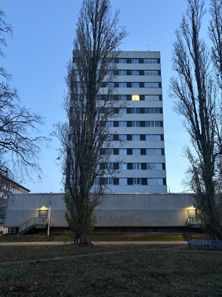 foto vom hochhaus am weddinger rathhausplatz. ein fenster ist beleuchtet, die anderen sind dunkel
