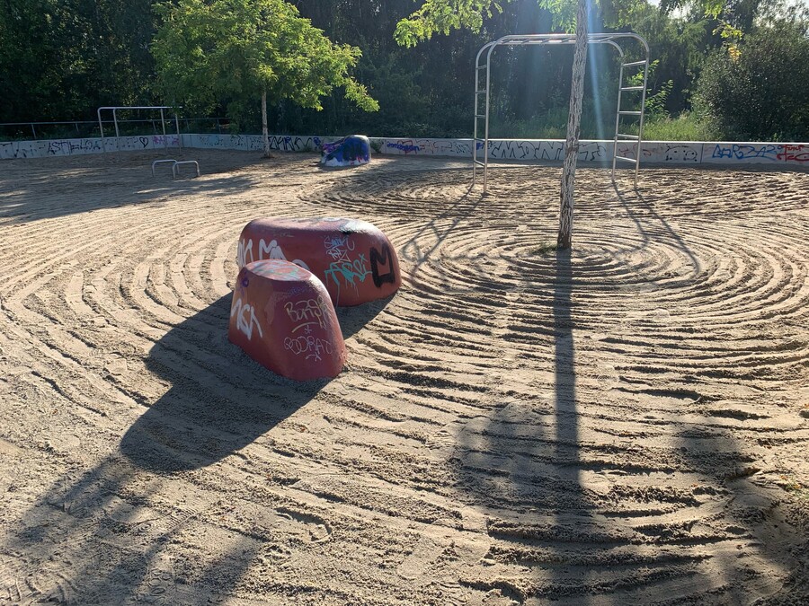 bild von einem sportplatz im park am nordbahnhof, in dem sich jemand die mühe gemacht hat und den sand sorgfältig mit kreisen versehen hat)