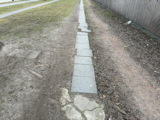 foto von ein paar gehwegplatten die sich durch die nutzung teilweise zur seite verschioben haben