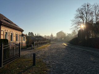 bild von einer strasse in summt, am horizont geht die sonne auf, die schatten sind lang.