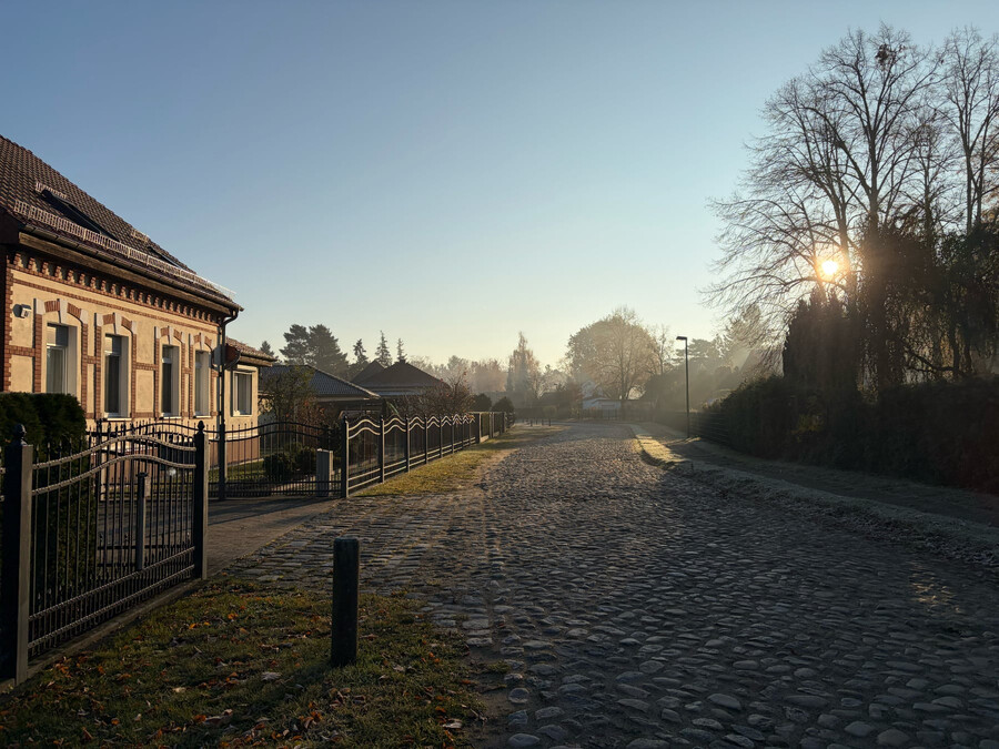 bild von einer strasse in summt, am horizont geht die sonne auf, die schatten sind lang.