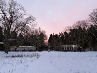 foto von der catcherwiese in richtung catcherstatue, im hintergrund beleuchtet die aufgehende sonne den himmel rosa
