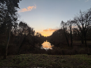 foto vom sonnenaufgang über dem möwensee in den regbergen. die wolken am himmel leuchten gift-orange