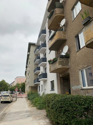 foto einer von zwei baugleichen häusern, eine fassade ist saniert, die andere nicht