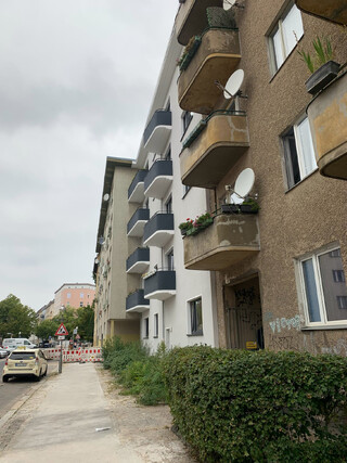 foto einer von zwei baugleichen häusern, eine fassade ist saniert, die andere nicht
