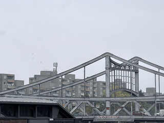 blick auf die graue swinem&uuml;nder br&uuml;cke, im hintergrund graue plattenbauten und grauer himmel.