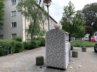 altkleidercontainer mit einem abgetrennten teddykopf auf der oberseite