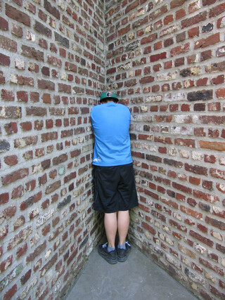 das kind steht in einer spitzen ecke aus rohen backsteinw&auml;nden