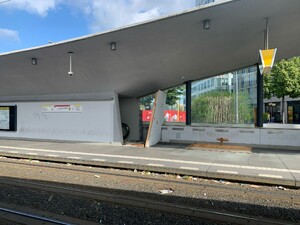 bild eines zerstörten holzverschlags an der tramhaltestelle am hauptbahnhof, man sieht dahinter eine rolltreppe