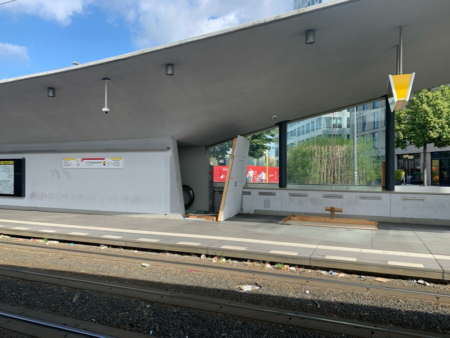 bild eines zerstörten holzverschlags an der tramhaltestelle am hauptbahnhof, man sieht dahinter eine rolltreppe