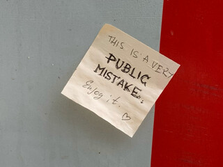 zettel mit der aufschrift: „this is a public mistake. enjoy it. <3“