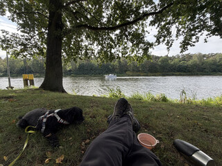frida und ich machen pause an der spree/m&uuml;ggelspree. man sieht die spree, einen baum, frida und ich liegen im gras.