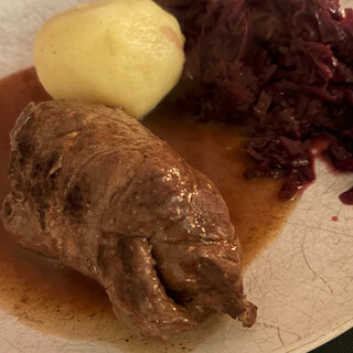 foto einer roulade, eines kartoffelkloss und rotkohl