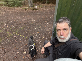 frida und ich machen pause im tegeler forst, ich sitze auf der achse eines bauwagens, frida trinkt aus einem schälchen wasser.