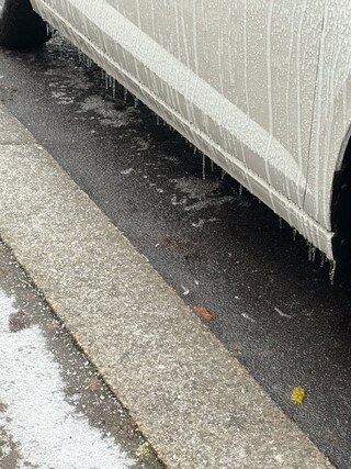 foto eiens geparkten autos das mit eis bedeckt ist und von dem eisz&auml;&uuml;fchen an der seite h&auml;ngen