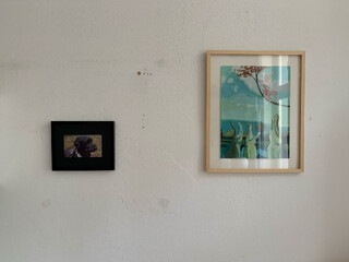 foto von der wand meines zimmers mit zwei bildern, eins davon ist der switchbot-rahmen mit einem portrait unseres pudels frida. sieht aus der entfernung ganz gut aus.