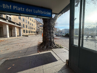 bild vom u-bahn-ausgang des platz der luftbrücke. es begrüsst einen ein alter knorriger baum.