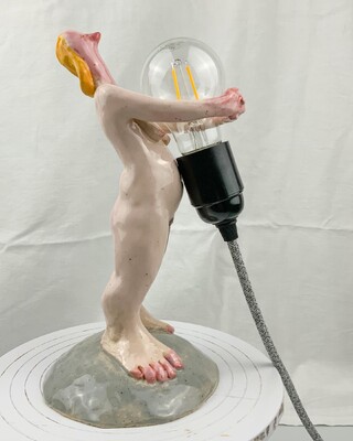 getöpferte nackte frau, die eine glühbirne umarmt