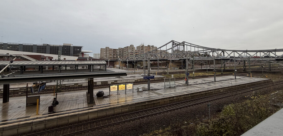 foto von der gleisanlage des bahnhof gesundbrunnen. im hintergrund sieht man grau-braune plattenbauten, eigentlich sieht alles grau-braun aus. sehr trist.