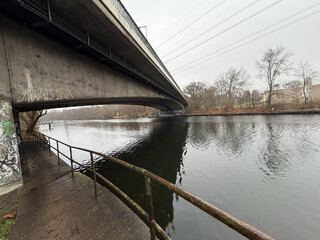 unter der br&uuml;cke am machmandelweg. der westhafenkanal glitzert, obwohl die sonne verdeckt ist.