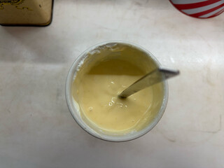 blick in einen mix-behälter mit frisch gemixter fruchtquarkspeise aus TK-mango, sahne, milch und quark.