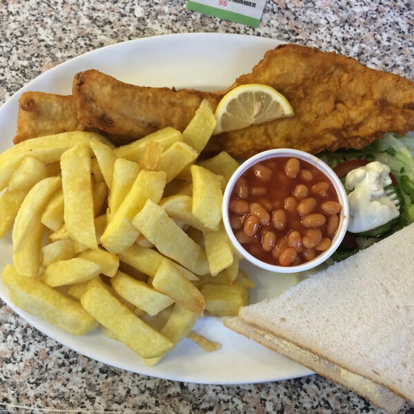 frit&shy;tier&shy;ter schell&shy;fisch mit di&shy;cken pom&shy;mes, boh&shy;nen, but&shy;ter&shy;toast und sa&shy;la&shy;ti&shy;mi&shy;tat.
