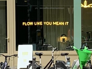 foto eines schaufensters in dem steht: „FLOW LIKE YOU MEAN IT“